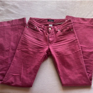 Röda low waist bootcut jeans - Snygga röda vintage bootcut jeans från E.V paris. Innerbenslängd: 84cm Midjemått: 36cm x2. Storlek och märke ses på sista bilden😊(lite liten i storleken)
