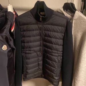 Moncler Cardigan - Säljer denna skitsnygga moncler cardigan i storlek S och färgen navy och jag säljer den eftersom den är för liten på mig.Den är såklart äkta och som ni ser på industri tagen så kan man legit checka.Den är perfekta till nu till våren och den är anpassad till alla årstider speciellt för våren och hösten. Man kan även ha den på milda vinter dagar och kalla sommar dagar. Denna Cardigan är perfekt till dig som letar efter en cardigan i storlek S och passar även Xs och XXs. ❗️pris går att diskutera❗️