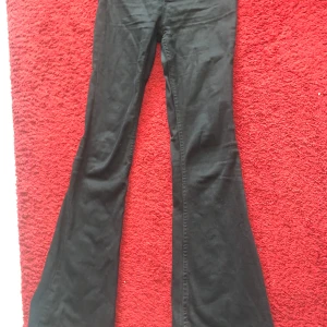 Svarta bootcut byxor - Säljer ett par svarta bootcut byxor med utsvängda ben. Byxorna har klassisk passform och är perfekta för dig som gillar en retrostil. Passar till många olika outfits och är ett måste i garderoben.