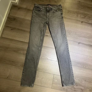 Grå Tommy Hilfiger Jeans  - Snygga grå jeansbyxor från Tommy Hilfiger med klassisk femficksdesign. Byxorna har en rak passform och är i storlek W30 L34. Skriv vid intresse.