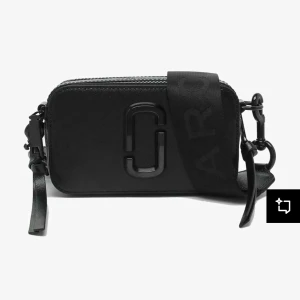 Svart axelväska från Marc Jacobs - En stilren väska från Marc Jacobs i modellen The Snapshot, i klassisk helsvart färg. Som har två separata fack och är en perfekt väska för vardagen. Väskan är tillverkad i läder med Marc Jacobs logotypen i mitten och svarta justerbara band.Kommer med en dustbag priset går att diskuteras.