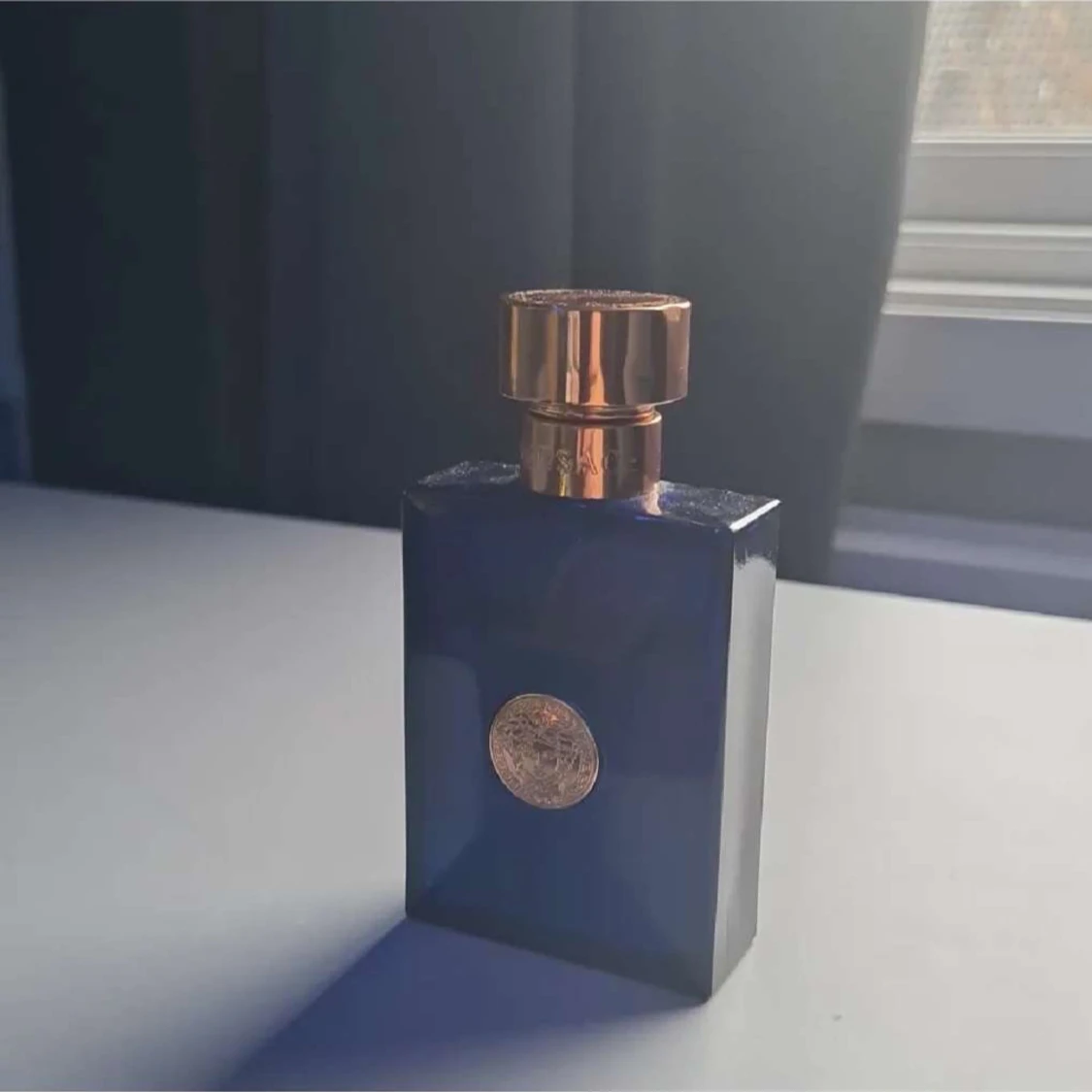 Blå parfymflaska med guldlock