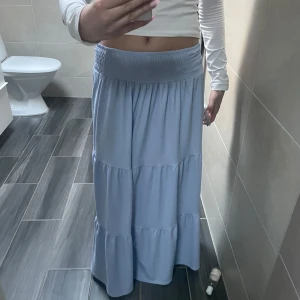 Ljuslila långkjol med volanger - Säljer en ljuslila långkjol med bred resår i midjan och flera volangpartier. Kjolen har en luftig och flowy känsla, perfekt för varmare dagar. Enkel att matcha med olika toppar för en avslappnad look. Som ny❤️❤️❤️