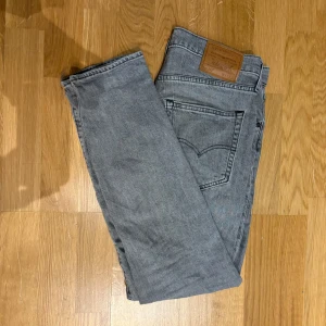 Grå jeansbyxor från Levi's - Säljer ett par grå Levi’s jeans som är snygga och trendiga. De är slim fit och du kan höra av dig om du vill ha fler bilder eller andra frågor. Pris kan diskuteras.