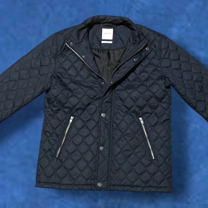 Quiltad jacka från Jack & Jones - Säljer denna mörkblå quiltad jacka från Jack & Jones med dragkedja och knappar framtill. Jackan har två praktiska fickor med dragkedja och en stilren design som passar perfekt för kyligare dagar. Vid minsta fråga eller fundering, tveka inte på att höra av dig🤝