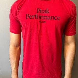 Röd t-shirt från Peak Performance - Skön passform och rund halsringning. Perfekt för dig som gillar stilrena och sportiga plagg.