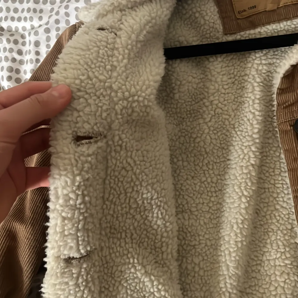 Säljer en brun manchesterjacka från 157 med vitt teddyfoder och krage. Jackan har knappar framtill, två bröstfickor med lock och klassisk jeansjacke-look. Perfekt för kyligare dagar och ger en cool vintagekänsla.. Takit.