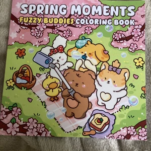 Spring Moments: Fuzzy Buddies Coloring Book - Färglägg söta och fluffiga djurvänner i våriga miljöer! Perfekt för dig som älskar gulliga karaktärer, picknickar och kreativa stunder. Boken är full av charmiga illustrationer som väntar på att få liv med dina färger. Skapa din egen värld med Fuzzy Buddies! En sida är målad