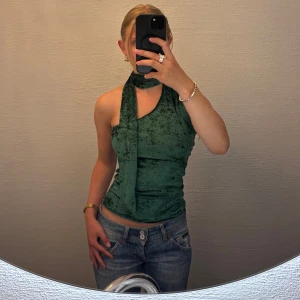 Grön halterneck topp - Snygg grön halterneck topp i mjuk sammet med unik omlott-detalj vid halsen. Toppen är egensydd av mig och passar runt s. Ställ gärna frågor! 💕