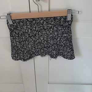 Svart blommig topp - Svart blommig av klippt kjol från WE. Helt okej skick.
