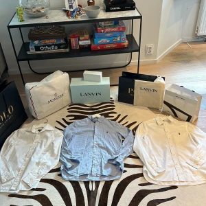 Ralph Lauren skjortor i bomull - Tre klassiska skjortor från Ralph Lauren i bomull, två vita och en ljusblå. Alla har lång ärm, knappar framtill och den ikoniska broderade polospelaren på bröstet. Perfekt för dig som gillar stilrena och tidlösa plagg med snygg passform. Däremot en liten defekt på blå skjortan skicka dm för bild!