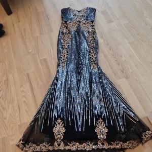 Finklänning med paljetter - Fin armlösfest klänning med paljettdesign silver och kopparpaljetter på svart. Passar S-M. Använd bara 2 gånger. 