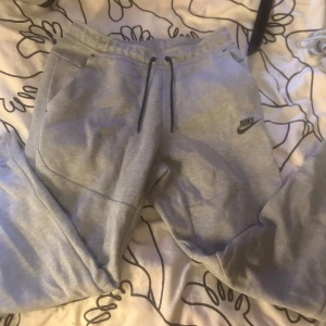 Grå mjukisbyxor från Nike - Snygga grå mjukisbyxor från Nike med svart logga på vänster ben. Använd bara en gång 