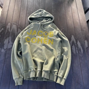 Jacob Cohen hoodie - Säljer denna riktigt feta Jacob cohen hoodie i storlek S. Den är knappt använd och i riktigt bra skick. Den ända flawn ser ni på tredje bilden där det har gått upp pytte lite på N:et! Bara att skriva kring fler frågor🤝🤩