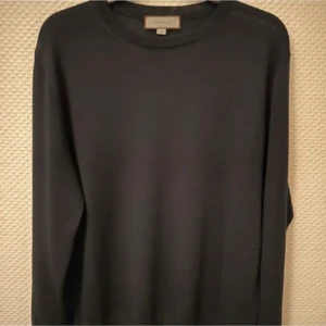 Svart/marinblå merinoulltröja från Canali - Svart/marinblå långärmad tröja från Canali, tillverkad i 100% extrafin merinoull. Klassisk rund hals och stilren design utan mönster eller detaljer. Perfekt för dig som gillar minimalistisk och lyxig stil. Italiensk kvalitet och riktigt skön känsla.