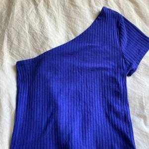 One shoulder topp  - Blå med ribbat material. Superbra skick 