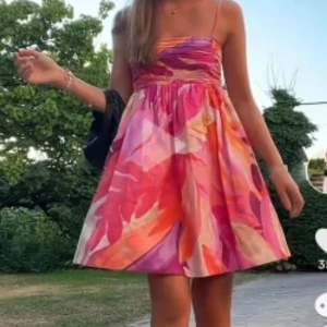 Färgglad klänning - Supersöt kortklänning med tunna axelband och färgstarkt blommigt mönster. Klänningen har en rynkad överdel och ett luftigt, utställd kjolparti. Perfekt för varma dagar och sommarhäng med vänner. Helt oanvänd med prislapp kvar, köpt på sellpy💞