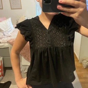 Svart blus med broderade detaljer💕 - Supersöt svart blus med broderade blommor och små hål i tyget upptill. 