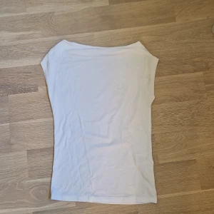 Vit ärmlös topp i bomull - En basic vit topp med ärmlös design och rund halsringning. Sitter tajt mot kroppen och är gjord i mjuk bomull, perfekt till jeans eller kjol. Enkel och stilren look som funkar året runt. Skriv för frågor💕