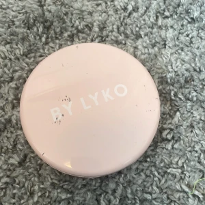 Rosa sminkspegel från By Lyko - Säljer en rund, bärbar sminkspegel i ljusrosa plast från By Lyko. Spegeln har två spegelytor och är perfekt att ha med i väskan för snabba touch-ups. Enkel och stilren design med By Lyko-logga på locket. Medflöjer kaddarsladd till lampan