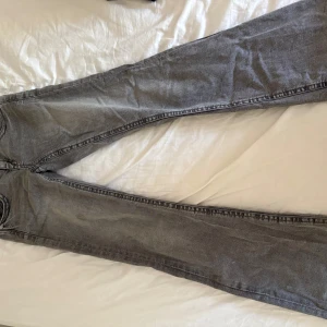 Grå jeans från Gina Tricot, storlek 152 - Snygga grå jeans från Gina Tricot i rak modell med klassiska fem fickor och coola detaljer på bakfickorna. Jeansen har normal passform och är tillverkade i mjukt bomullsmaterial. Perfekt för dig som gillar en enkel men stilren look.