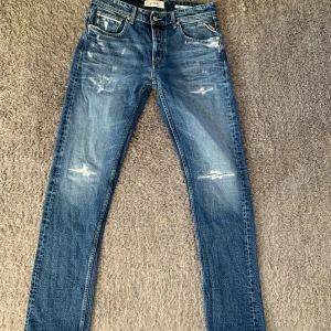 Replay jeans - Snygga Replay Grover jeans i klassisk blå tvätt med slitna detaljer och raka ben. Jeansen har fem fickor, tydliga Replay-loggor och kontrastsömmar. Dom är i super bra skick och endast testade. Storlek W31 L32. priset är fast.
