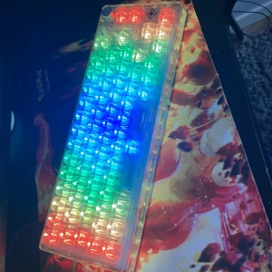 65% Layout Transparent Mechanical Gaming Keyboard - Snyggt transparent gamingtangentbord med RGB-belysning i regnbågens färger. Perfekt för dig som vill sticka ut på gamingkvällarna och gillar cool design. Kompakt 65%-layout, hot-swappable switches och mjukvara för anpassning. Gör din setup unik!
