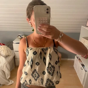 Mönstrad linnetopp med tunna axelband - Säljer en luftig linnetopp med svartvitt mönster och tunna axelband. Toppen har en avslappnad passform och är perfekt för varma dagar.