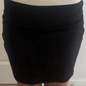 Svart tight kortkjol - Enkel och stilren svart kortkjol med tight passform. Har en defekt då jag råkade sätta mig på en blå bänk när den ej var torr💓 Syns inte så mycket och man kan säkert fixa de! 