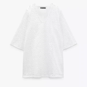 Vit broderad klänning från Zara - Superfin vit klänning från Zara med broderade detaljer och v-ringning. Klänningen har trekvartsärm och är i kort modell. Tak i modellen och ger en väldigt elegant look. Kommer tyvärr inte till användning. 