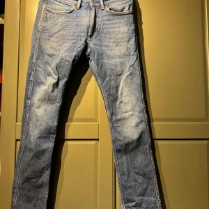 Blå jeans från Acne Studios 30/32 - Snygga blå jeans från Acne Studios i klassisk tvätt. Modellen har raka ben, fem fickor och orangea kontrastsömmar. Jeansen är i bomull och har en stilren look som funkar till det mesta. Märkespatch bak i midjan.