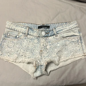 Lågmidjade jeansshorts - Lågmidjade jeansshorts som har spets broderi och är i ljus blå färg. De är från Tally Weijl i storlek 34 vilket motsvarar XS. Midjemått rakt över 37,5 cm. INTRESSEKOLL!! Kom privat för annat💕