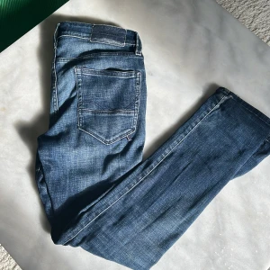 Jack & Jones Slim Glenn jeans blå 27/30 - Snygga blå jeans från Jack & Jones i modellen Slim Glenn. Jeansen har en slim passform. Färgen är mellanblå med lätt slitning och kontrastsömmar. Dom är använda men fortfarande väldigt bra skick på dom 27/30 i storlek. Priset går alltid att diskutera😊
