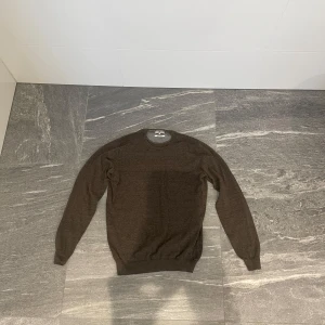 Tröja från Hansen & Jacob - Säljer en brun långärmad tröja från Hansen & Jacob i kammad bomull. Tröjan sitter snyggt storlek S men passar också Xs. Tveka inte på att höra av dig vid minsta funderingar!