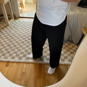 Svarta kostymbyxor från Uniqlo - Svarta oversized kostymbyxor från Uniqlo i storlek S. Dessa är dammodell och har en rak / loose passform med hög midja och hällor för bälte. Materialet är en mix av polyester, viskos och elastan = mjuka och något elastiska. Tror dessa har utgått ur deras sortiment så passa på!