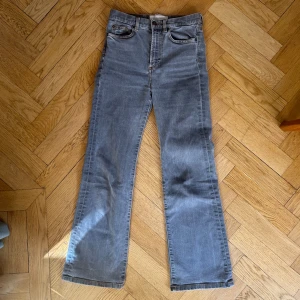 Gråa bootcut jeans från Jeanerica - Snygga grå jeans från Jeanerica med bootcut passform och hög midja. Jeansen har klassiska fickor, raka ben med lätt utsvängning och kontrastsömmar. Storlek 25/32. Bra skick!