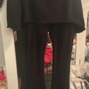 EMP Svarta byxor med snörning i sidan - Säljer ett par svarta EMP byxor med snygg snörningsdetalj längs ena sidan. Byxorna har en rak passform och är tillverkade i ett mjukt material som känns skönt mot huden. Perfekta för dig som vill ha en stilren look med en twist. Hann inte lämna tbx den i tid helt ny endast provad!