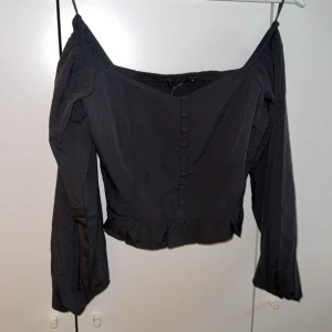Off shoulder top - Svart off shoulder top från Bikbok, har små volanger nedtill. Stl M men sitter mer som XS/S. Oanvänd, prislappen på! Hör av er för fler bilder 