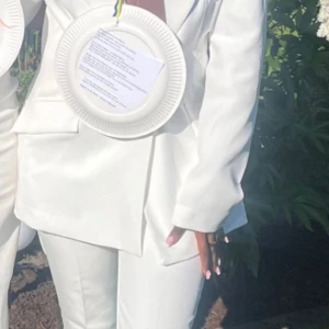 Vit kavaj - Säljer en stilren vit kavajkostym med klassisk kavaj och matchande raka byxor. Kostymen har en snygg, modern passform och är perfekt för dig som vill sticka ut med en fräsch look. Passar till student eller andra speciella tillfällen.