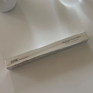 Rapide Cosmetics, Highlight Cover Stick  - Highlight Cover Stick från Rapide Cosmetics i nyansen Warm Passionate. Kommer i en stilren, silvrig förpackning. Perfekt för att ge ansiktet en fräsch glow och framhäva dina drag med en varm ton.