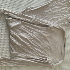 Beige lång klänning XS - Säljer en beige långärmad klänning från 157 i storlek XS. Perfekt för dig som gillar neutrala färger och en clean look. Passar dig som vill ha en basic klänning med lite struktur.