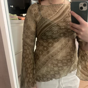 Grön  mönstrad meshtröja från Vila - Grön långärmad med glitter och utsvängda ärmar.  