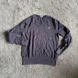 Ralph Lauren tröja  - Mörkblå v-ringad tröja från Polo Ralph Lauren med klassisk broderad logga på bröstet. Tröjan har långa ärmar, ribbade muddar och är gjord i mjuk bomull. Perfekt för dig som gillar stilrena och tidlösa plagg. Mått: ca 58 cm längd, ca 42 cm bredd. Storleken är XL 18-20 år vilket bör motsvara S men kolla måtten :)