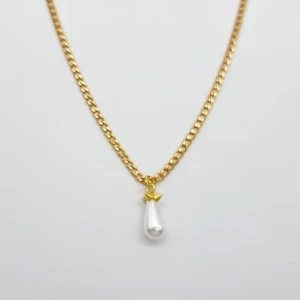 Guldhalsband med pärl-droppe - Stilrent halsband i guldtonad kedja med en droppformad vit pärla som hänge, dekorerad med en liten guldfärgad detalj upptill. Perfekt för dig som gillar klassiska smycken med en modern twist.
