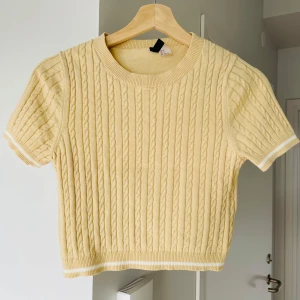 Ny Gul kabelstickad topp - 👕 Inga skador, rena och i nytt skick. Kortärmad kabelstickad topp från H&M Divided.  Säljer eftersom storleken inte längre passar.
 Mått:
 • Längd: ca 43 cm
 • Bröst: ca 40 cm
 • Material: 59% bomull, 41% akryl
 📦 Kan hämtas i Kista, Stockholm, eller skickas
 Tveka inte att höra av dig vid intresse eller frågor!
