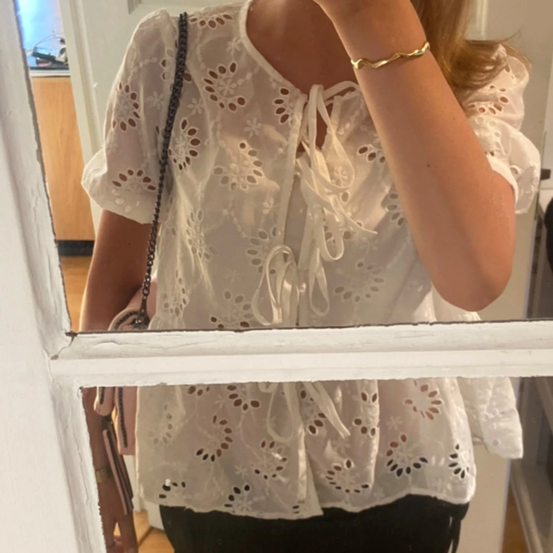 Vit blus med broderade blommor och knyt