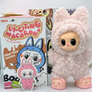 Lafufu Lychee Berry med gullig dräkt & skor - Supersöta rosa Lafufu Lychee Berry Exciting Macaron Hon har på sig en ljusrosa jättegullig & mjuk teddy oncie som har en hoodie med öron och den stängs med en knapp Lychee får oxå med sig ett par supergulliga rosa gris tofflor, dom är lite stora, men hon står jättebra i dom Orginalkartongen, foliepåsen och Lychee Berry kortet ingår oxå Dock är kartong & påse öppnade Hon har vridbart huvud, händer och fötter. Både Lychee & outfiten är i jättefint skick! Höjd 17cm