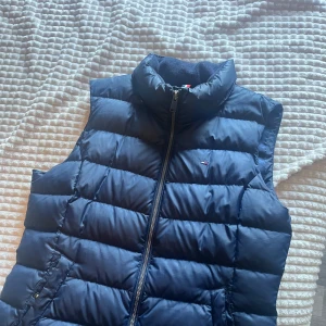 Mörkblå dunväst från Tommy Jeans - Skicka 8/10 Snygg mörkblå dunväst från Tommy Jeans Perfekt att slänga över en hoodie . Storleken är L men passar M med. Priset kan diskuteras 