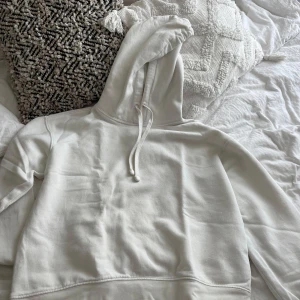 Vit hoodie från Zara med snörning - Säljer en stilren vit hoodie från Zara i storlek S. Tröjan har en klassisk huva med snörning och är långärmad. Mjuk och skön bomullskvalitet som passar perfekt för chill dagar. Enkel design utan mönster eller tryck.