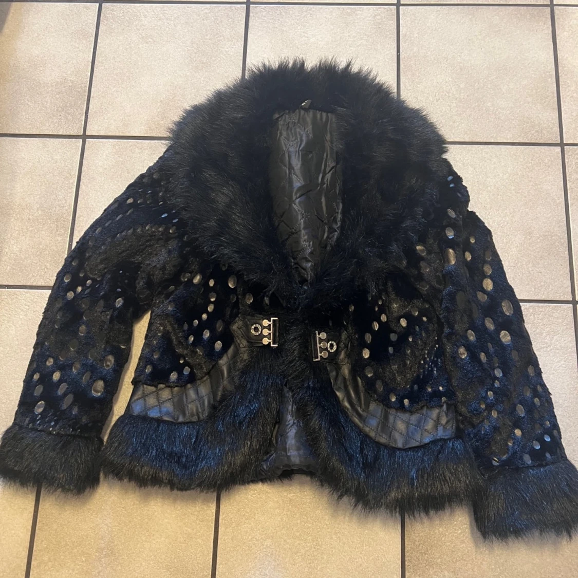 Svart pälsjacka med prickigt mönster
